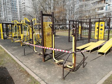 Sokaktaki spor sahası kapalı ve bantla çevrili. Koronavirüsün yayılmasını önlemek için karantina önlemleri. İnsanların kendini izole etmesi