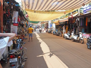 GOA, INDIA, 27.02.2020 Kuzey Goa 'daki Arambol köyünde ana cadde. Bir sürü dükkan ve bisikletli insan.