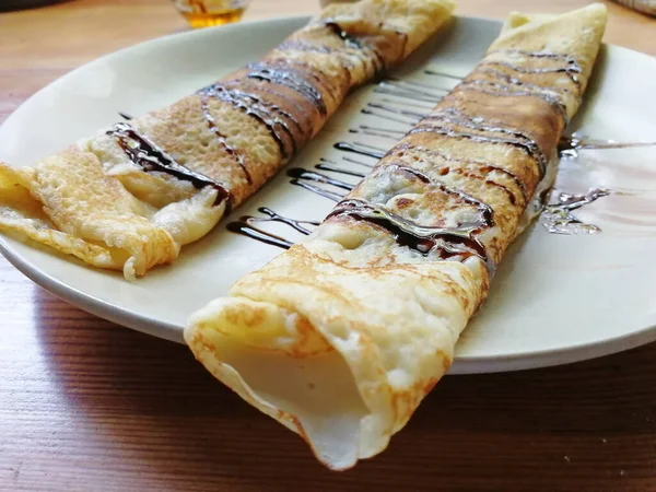 Pannenkoeken Gerold Een Buis Liggend Een Bord Gegoten Met Chocolade — Stockfoto