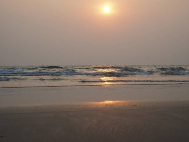 Yazın deniz ve plajın arka planında güzel bir günbatımı. Tatil ve tatil kavramı