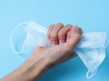 Koruyucu tıbbi maske eline yapışmış. Virüslere, bakterilere ve hastalıklara karşı korunma konseri