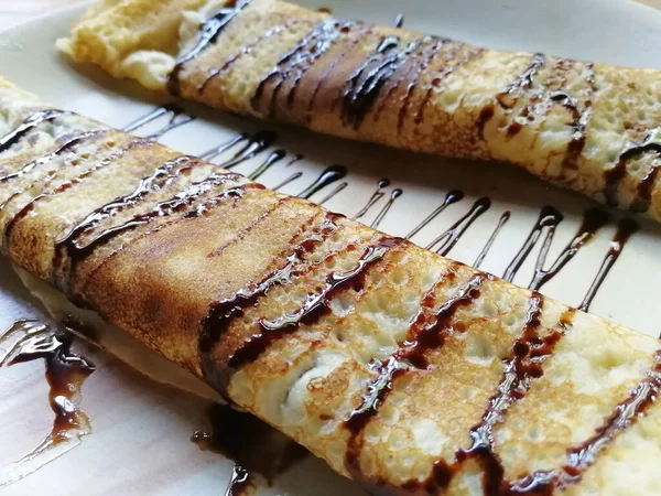 Pannenkoeken Gerold Een Buis Liggend Een Bord Gegoten Met Chocolade — Stockfoto