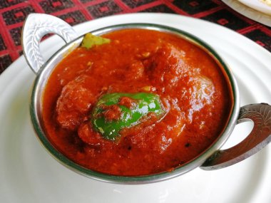 Kakai 'deki tavuk Tikka Masala, beyaz bir tabakta, yakın plan. Lezzetli Hint tavuğu.