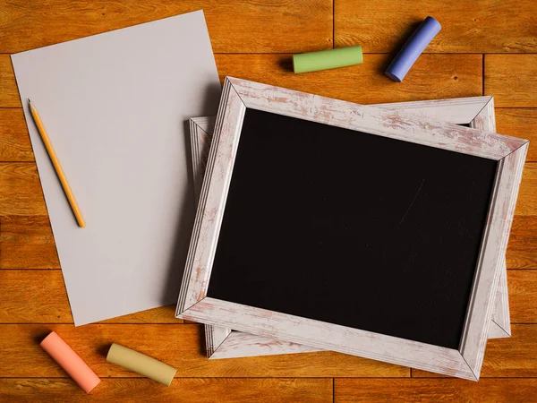 Chalkboard e giz colorido sobre mesa de madeira. Ilustração 3D — Fotografia de Stock