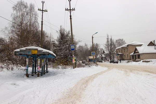 Parada de autobús frente a la nevada en una pequeña ciudad provincial . — Foto de Stock