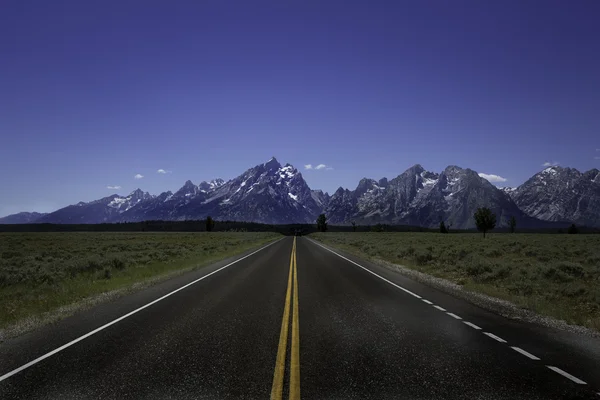 Estrada rural que conduz aos Grand Tetons — Fotografia de Stock