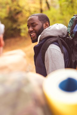 Genç gülümseyen adam backpacker 