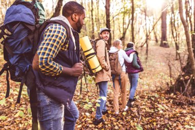 Young backpackers in autumn forest clipart