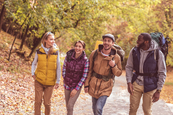 Happy young backpackers in forest