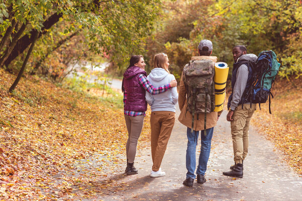 Young backpackers in autumn forest