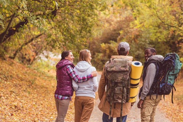 Young backpackers in autumn forest