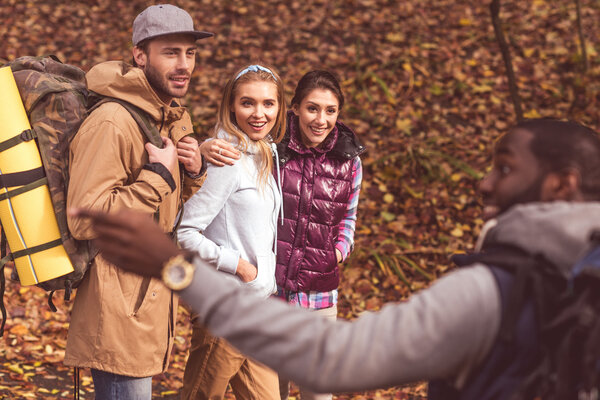 Smiling man with friends in autumn forest