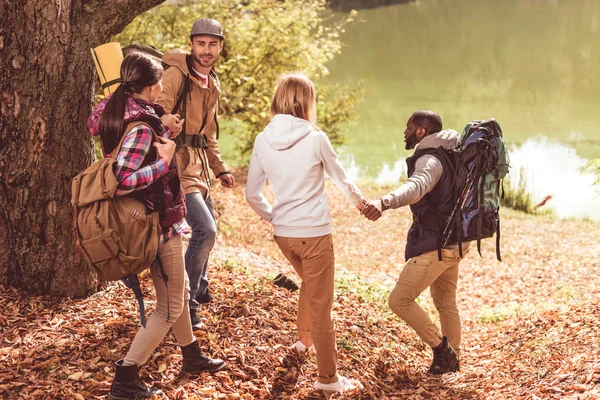 Men helping women go to river — Stock Photo, Image