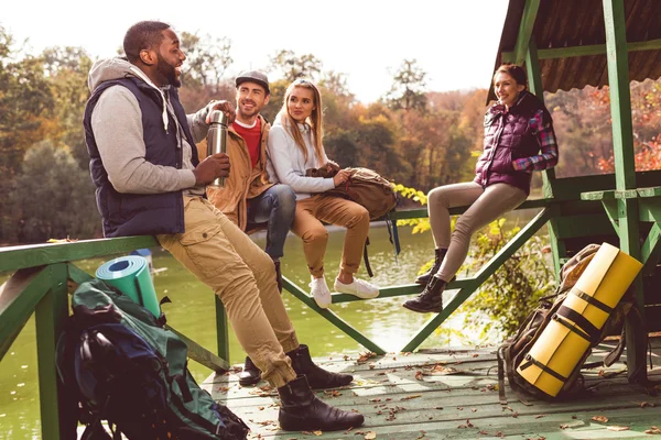 Young travelers resting near river — Stockfoto