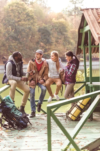 Young travelers resting near river — Stock Photo, Image