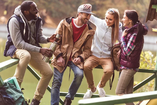 Young travelers resting near river — Stock Photo, Image