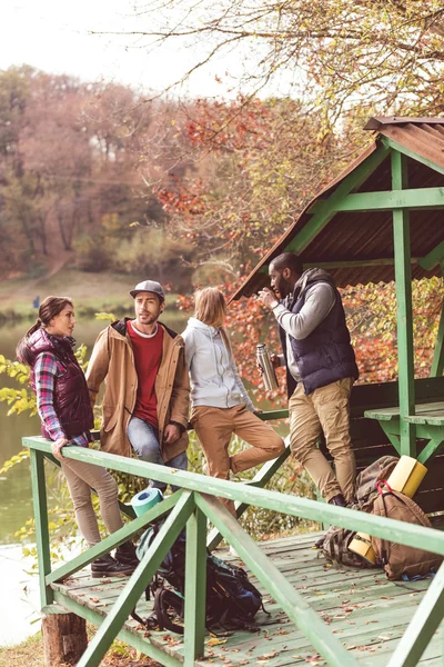 Young travelers resting near river — Stock Photo, Image