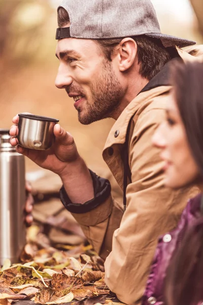 Joven sosteniendo la taza del termo — Foto de Stock