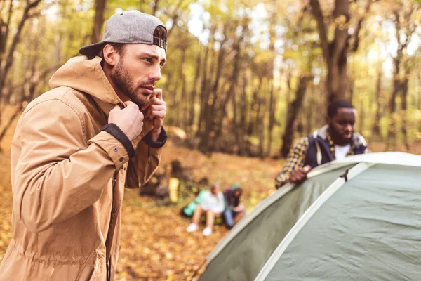 Men pitching tent in autumn forest — Stock Photo, Image