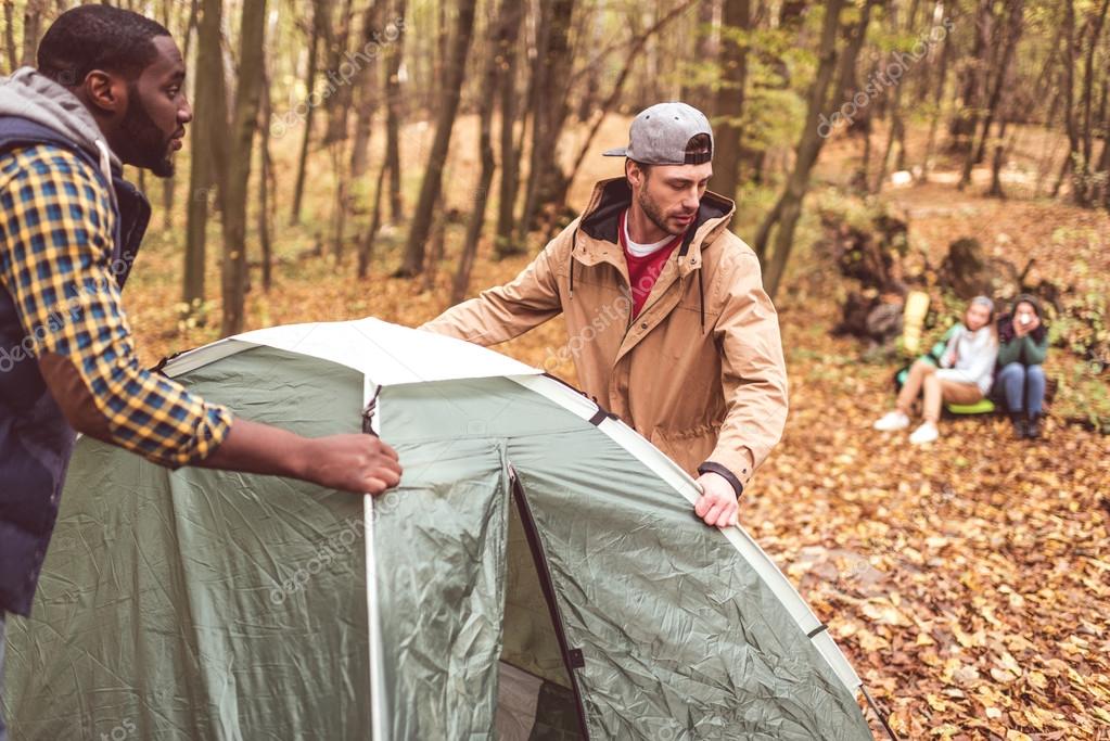 Men pitching tent in autumn forest — Stock Photo © ArturVerkhovetskiy