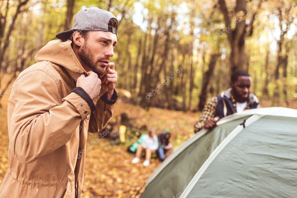 Men pitching tent in autumn forest — Stock Photo © ArturVerkhovetskiy