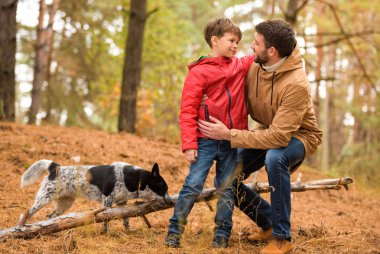 Happy boy playing with father and dog  clipart