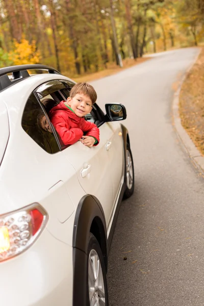 Anak tersenyum melihat melalui jendela mobil — Stok Foto