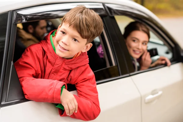 Uśmiechnięty chłopiec patrząc przez okno samochodu — Zdjęcie stockowe