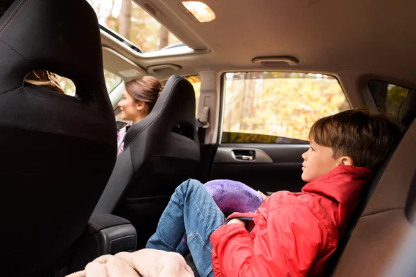 Sonriente niño en el asiento trasero del coche — Foto de Stock