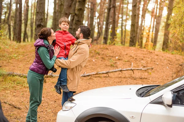 Happy family near car in forest