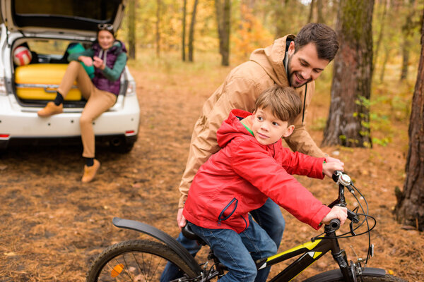 Father teaching son to ride bicycle