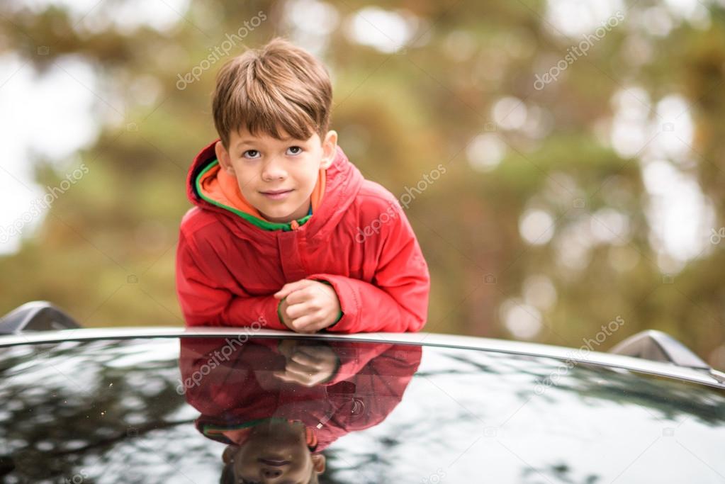 Cute little boy standing in car 