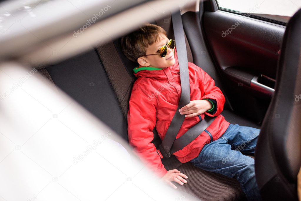 Smiling boy in back seat of car