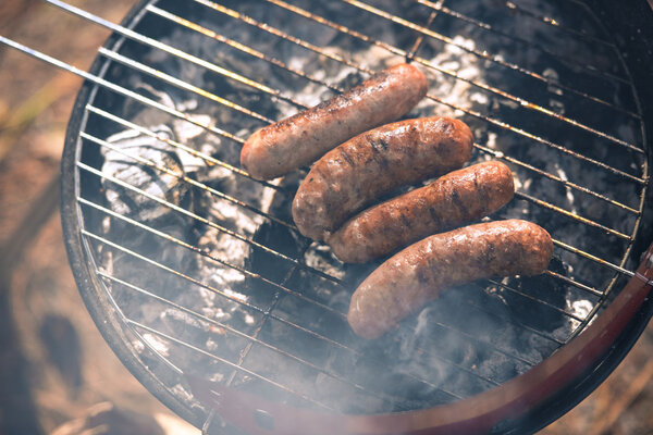 Grilling sausages on barbecue grill