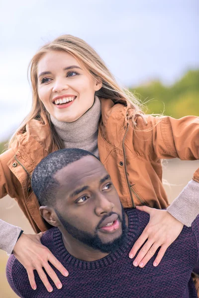 Happy young couple piggybacking — Stock Photo, Image