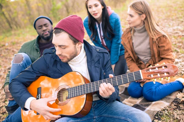 Amigos apreciando guitarra no parque de outono — Fotografia de Stock