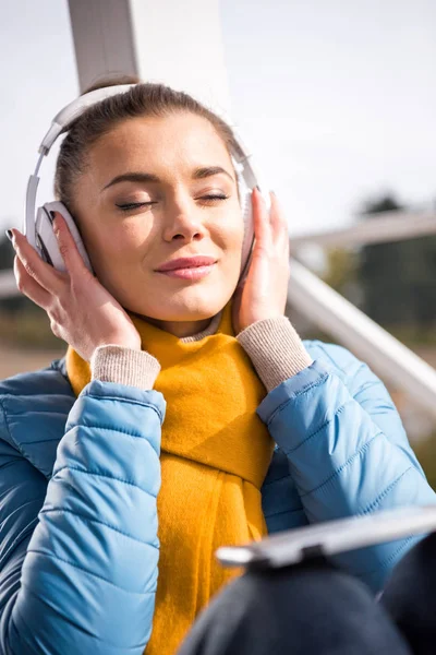Schöne Frau mit Kopfhörer, die Musik hört — Stockfoto