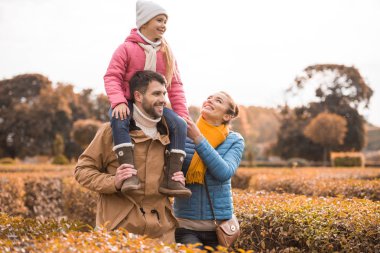 Mutlu bir aile parkta yürüyor.