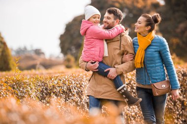 Mutlu bir aile parkta yürüyor.