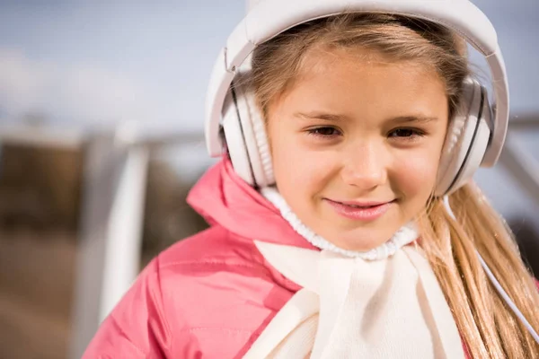 Niña sonriente con auriculares blancos — Foto de Stock