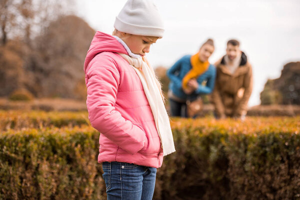Sad little girl standing outdoors