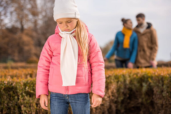 Sad little girl standing outdoors