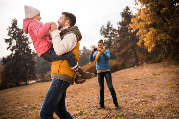 Man playing with little daughter in park