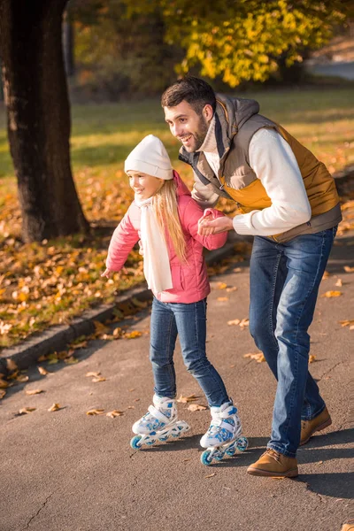 Pai ensinando filha a patinar — Fotos gratuitas