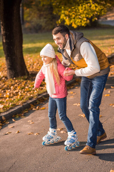 Father teaching daughter to roller skating