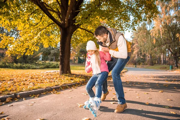 Pai ensinando filha a patinar — Fotografia de Stock