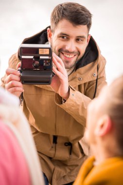 Man photographing happy mother and daughter clipart