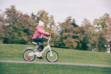 Parkta bisiklete binen küçük kız