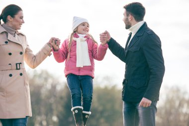 Mutlu bir aile parkta yürüyor.
