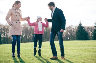 Mutlu bir aile parkta yürüyor.